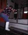 Persona con gamba ingessata che tenta di salire sul treno