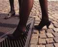 Donna con scarpe con tacchi a punta sottile che cammina su un grigliato