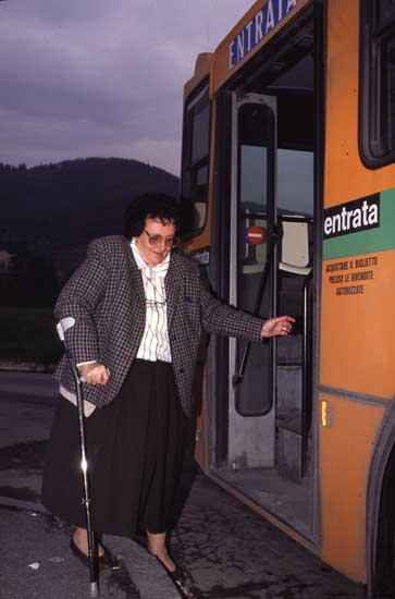 Persona con bastone che cerca di salire sull'autobus